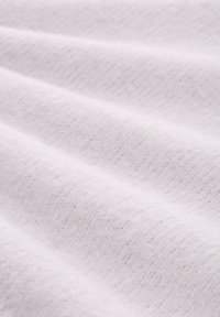 Tissu blanc texturé avec des plis ondulés, présentant une surface douce et pelucheuse ainsi qu'un motif de tricot fin, suggérant chaleur et confort.