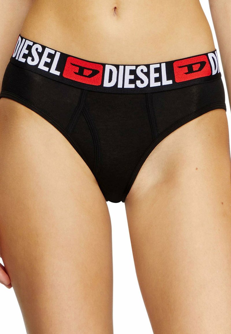 Zwarte katoenen slip met een brede elastische tailleband waarop de merknaam "DIESEL" in wit en rood is afgebeeld. Zichtbaar zijnaad detail.