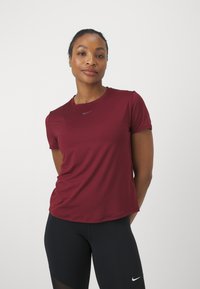 Burgundia lühikeste varrukatega sportlik t-särk ümmarguse kaelusega, mille keskel on väike hall Nike logo. Sile kangas, mugav lõige.