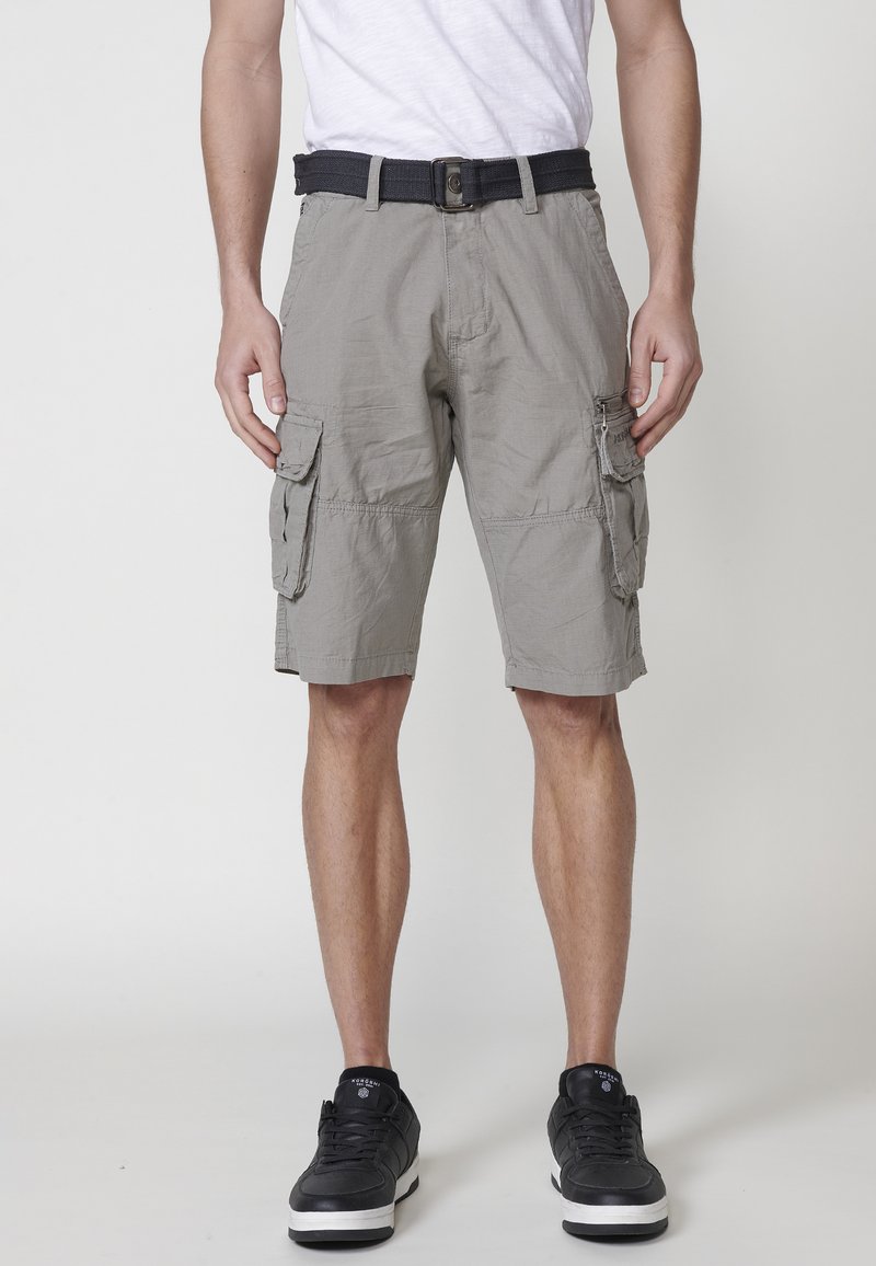 Shorts cargo en tissu gris clair, dotés de plusieurs poches sur le côté, d'une ceinture noire à la taille et d'une coupe décontractée.