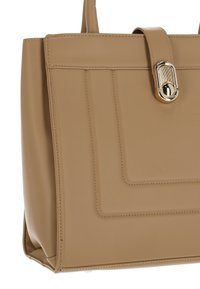 Beiger Kunstlederhandtasche mit strukturiertem Design, ausgestattet mit einem oberen Griff, einer Klappe als Verschluss und kontrastierenden Nähten. Akzente aus goldfarbenem Metall.