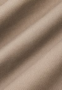 Tkanina w kolorze beżowym o teksturowanym wzorze, z równoległymi żeberkami i gładkimi obszarami, prezentująca subtelny połysk i trwałość.