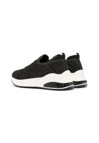 Black knitted sneakers with a textured upper, white midsole, and black rubber outsole with bubble accents. Loop detailing on the heel.