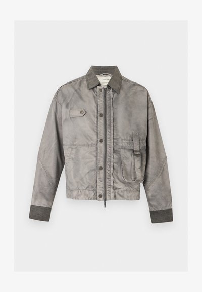 Γκρι μακρυμάνικο μπουφάν με μπροστινό φερμουάρ και κουμπιά, θήκη στο στήθος με καπάκι και πλαϊνή θήκη με λεπτομέρεια αγκράφας.