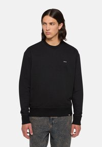 Sudadera negra con cuello redondo, puños y dobladillo acanalados, que presenta una pequeña etiqueta de logo en el pecho. Confeccionada en una suave tela texturada.