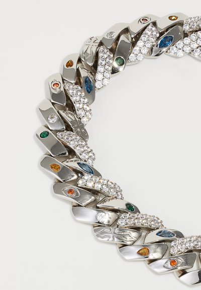 Silver chain bracelet with alternating links featuring multicolored gemstones, clear crystals, and engraved cross and eye symbols.