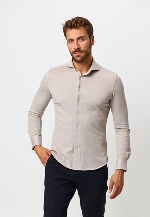 Hellbeige Langarmhemd, mit Knopfleiste und weichem Material, ausgestattet mit einem spitzen Kragen und geknöpften Ärmeln.