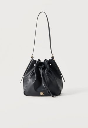 Čierna kožená kabelka v tvare vedra so šnúrkovým zapínaním, jedným ramenným popruhom a malým zlatým logom "HUGO" uprostred prednej strany.