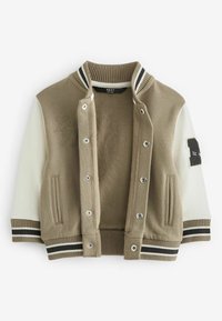 Veste universitaire beige et crème avec col, poignets et bas rayés, boutons-pression à l'avant, poches latérales et un écusson sur la manche droite.