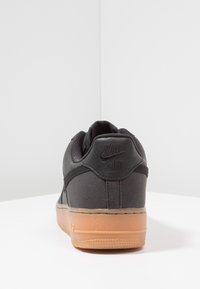 Teniska Nike Air z černé tkaniny a kůže s gumovou podrážkou. Má polstrovaný límec a vyražené logo na patě.