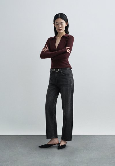 Μπλούζα από πλεκτό υλικό μπορντό με μακριά μανίκια και βαθύ V ντεκολτέ, συνδυασμένη με ψηλόμεσα μαύρα τζιν σε ίσια γραμμή και μαύρες μυτερές μπαλαρίνες.