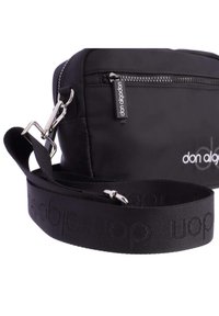 Bolsa cruzada de nylon negra con cierre de cremallera, etiqueta con logo y una amplia correa ajustable con tejido estampado. Incluye acentos de hardware plateado.