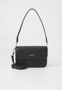 Black leather crossbody bag with a textured finish, magnetic flap closure, adjustable strap, and silver logo on the front.