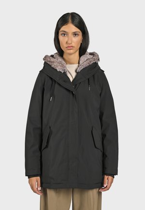 Zwarte parka jack met een nepbont gevoerde capuchon, ritsluiting en zijzakken. Beschikt over een ontspannen pasvorm en duurzame, waterafstotende stof.