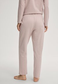 Lichtroze pyjama set met een herhalend klein geometrisch patroon. Gemaakt van zachte stof, met een elastische tailleband en lange mouwen.