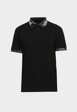 Must must-shirt nupuväelistega ja mustrit sisaldavate kaeluse ning mansettidega. Omab ühtlast keha ja dekoratiivseid aktsente hallis.