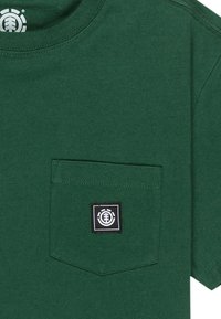 T-shirt en coton vert avec col rond, manches courtes et une poche avant arborant un logo carré noir avec un design circulaire.