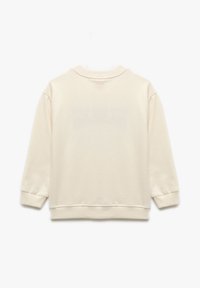 Krämfärgad sweatshirt med avslappnad passform, ribbade ärmslut och hals, mjuk textur och inga synliga tryck eller mönster på baksidan.
