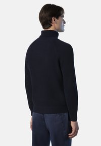 Marineblauer gerippter Rollkragenpullover mit taillierter Passform. Hat einen hohen Kragen und lange Ärmel. Weiche Textur mit horizontalem Streifenmuster.