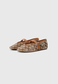Flat shoes with a tan strap and buckle, made of textured fabric featuring a brown pattern on a lighter background.