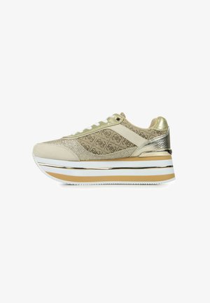 Platform sneakers with a beige fabric upper featuring a pattern, gold accents, silver hardware, and white midsole with striped detailing.