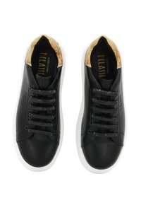 Sneakers in pelle nera con suola in gomma bianca, lacci texturizzati e una bordatura marrone a motivi attorno al collare. Design semplice e moderno.