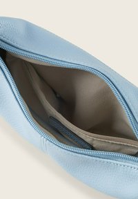 Light blue leather pouch with a textured exterior. Interior features a beige lining with pockets for organization. Zipper closure on top.