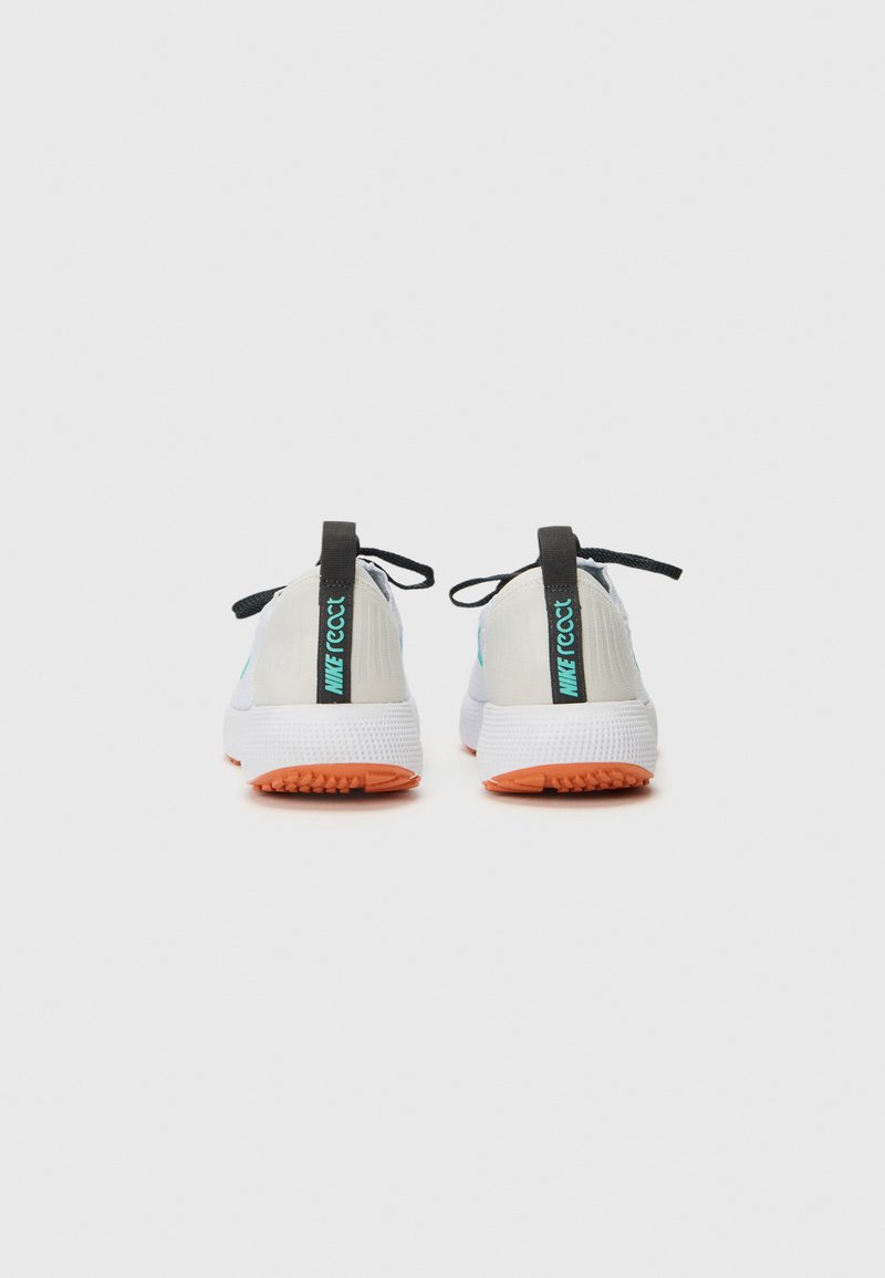 Buty sportowe z białą i jasnoniebieską cholewką, czarnymi akcentami i pomarańczową podeszwą. Mają paski do chwytania oraz czarne sznurówki zapewniające pewne dopasowanie.