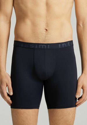 Dunkelblaue Boxer-Shorts aus einem glatten, dehnbaren Stoff. Sie verfügen über einen weichen Bund mit eingeprägtem Markennamen und eine konturierte Vorderseite.