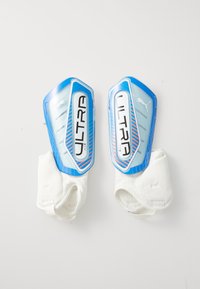 Ett par blå och vita Puma Ultra Flex fotbollsskydd med ett skyddande plasthölje och fästa vita ankelärmar.