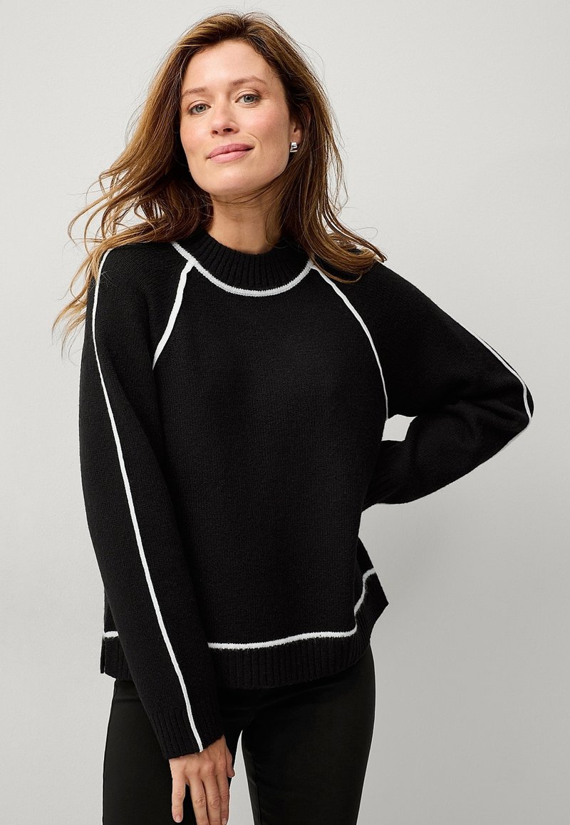 Maglione nero a maglia con colletto alto, strisce bianche decorative lungo le maniche raglan e l'orlo inferiore, e polsini e orlo a coste.