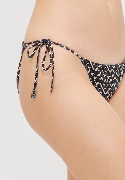 Bikini apakša melnbaltā leopardu rakstā ar regulējamiem sānu saitēm un gludu tekstūru. Zema jostas līnija ar minimālu segumu.