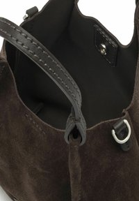 Bruine suède handtas met leren accentueringen, met een zachte textuur, een enkele handgreep en een drukknoopsluiting aan de binnenzijde.