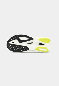 Semelle de chaussure de course Hoka présentant une base blanche, des sections en caoutchouc noir texturé et des accents vert vif avec des motifs découpés.