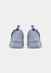 Zapatillas deportivas de color azul claro con parte superior texturizada, cuello acolchado y tira de sujeción; cuentan con una suela lisa con patrones de agarre.