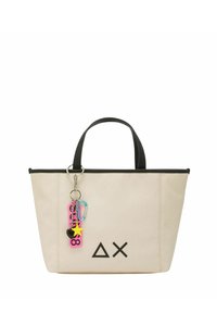 Borsa tote beige con rifiniture nere, caratterizzata da un logo geometrico, due manici robusti e un charm colorato con varie forme e colori.