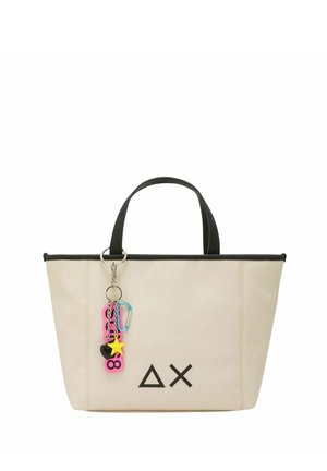 Bolso tote beige con ribete negro, que presenta un logo geométrico, dos asas resistentes y un charm colorido con diversas formas y colores.