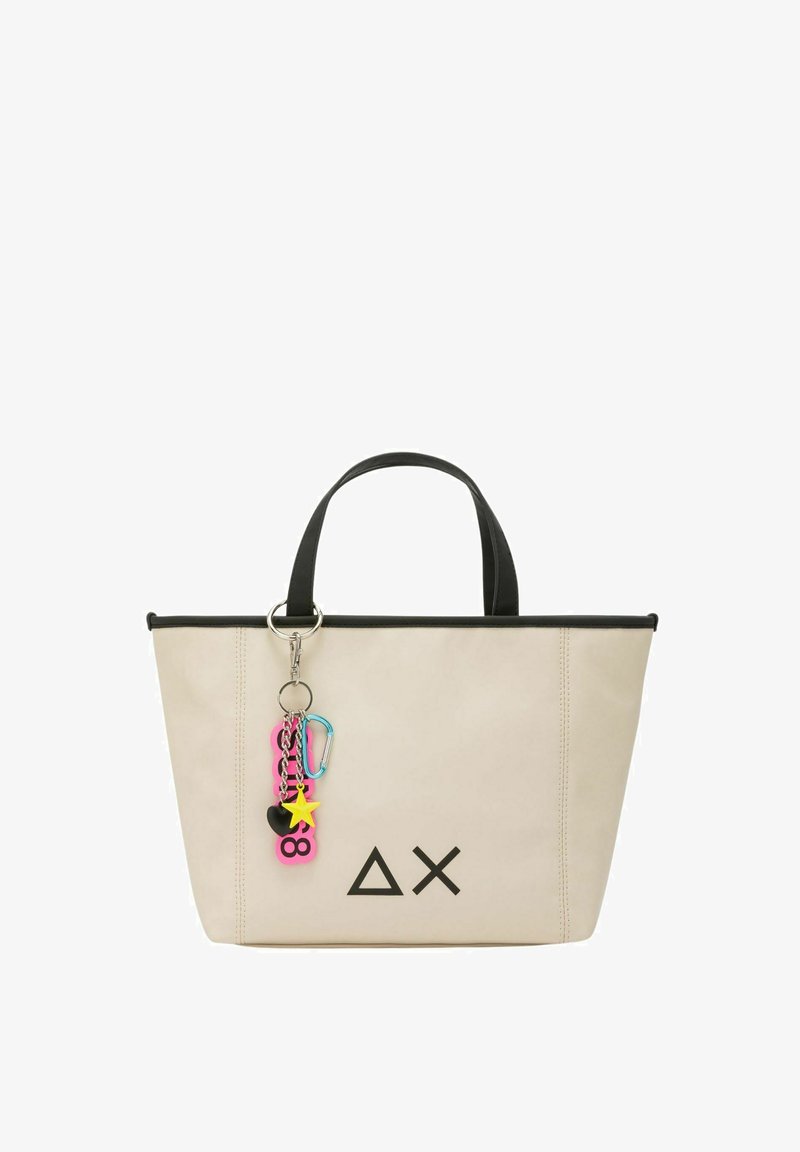Borsa tote beige con rifiniture nere, caratterizzata da un logo geometrico, due manici robusti e un charm colorato con varie forme e colori.