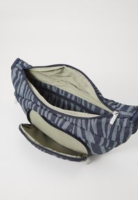 Borsa in tessuto con motivo geometrico blu, dotata di due scomparti con zip; rivestimento interno in rete; tessuto interno beige a contrasto.