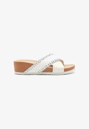 Sandali platform bianchi con cinturini incrociati, caratterizzati da una trama intrecciata e dettagli argentati. Sottopiede imbottito color beige con bordi bianchi.