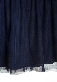 Falda de tul azul marino con un diseño en capas, que presenta una superficie texturizada, un acabado suave y un dobladillo ligeramente transparente.