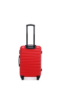 Hard-shell red suitcase with a ridged design, black retractable handle, and four wheels for easy mobility. Side handle for carrying.