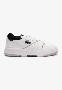 Hvite sneakers med svarte detaljer, som har et glatt lærkonstruksjon, rund tå, sømdetaljer og en gummisåle med mønster for godt grep.