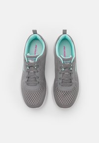 Szare buty sportowe z siateczkową cholewką, jasnoturkusowymi akcentami, sznurowanym zapięciem oraz solidną białą podeszwą. Wewnątrz widoczne logo "SKECHERS MEMORY".