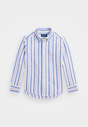 Chemise à manches longues boutonnée avec des rayures verticales bleues, blanches, jaunes et orange, et un petit logo brodé sur la poitrine gauche.