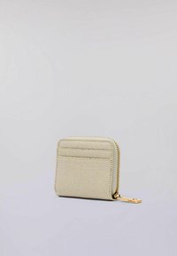 Piccolo portafoglio in pelle beige con zip dorata e tasche esterne per carte su uno sfondo neutro.