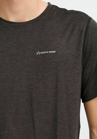 Camiseta de manga corta gris oscuro hecha de una tela texturizada con un sutil patrón jaspeado, que presenta un pequeño logo blanco "NORTH BEND" en el pecho.