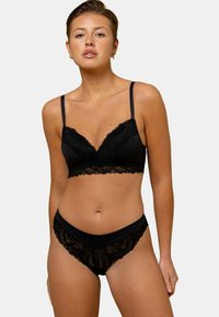 Ensemble de lingerie en dentelle noire comprenant un bralette avec des bretelles ajustables et une culotte taille haute assortie avec des bords festonnés et des motifs floraux.