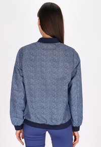 Marine blauwe bomberjack met een gespikkeld patroon, ribgebreide manchetten en kraag, elastische zoom en zachte textuur. Ontworpen voor comfort en casual gebruik.