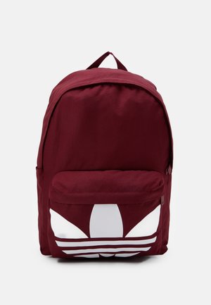 Ciemnoczerwony plecak z dużym białym logo trefoil na przedniej kieszonce, wyposażony w górny uchwyt i zapinane na zamek przegrody.